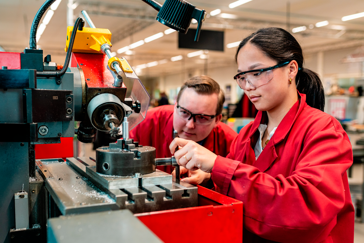 Mechatronica studenten met veiligheidsbril in praktijkruimte aan het werk