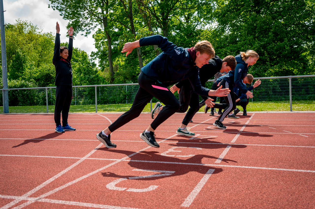 Studenten rennen weg op atletiekbaan